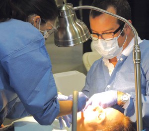 A volunteer dental team works on a patient 