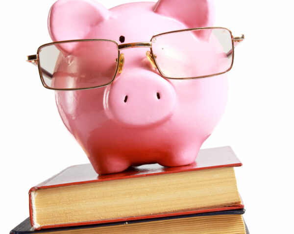 piggy bank with glasses and book isolated white background