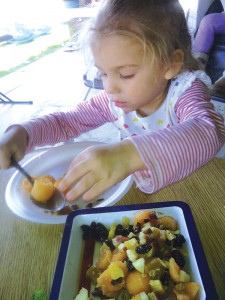 Kailani Clifford, 3, serves herself some fruit salad at Gil Family Child Care in Coachella