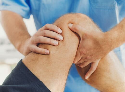Physical therapist helping patient with knee