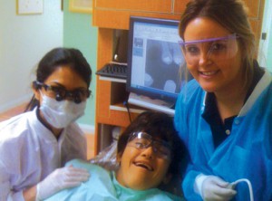 Western University dental students with their smiling We Care Dental patient